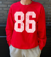 Red colored pullover with white text that says "86"