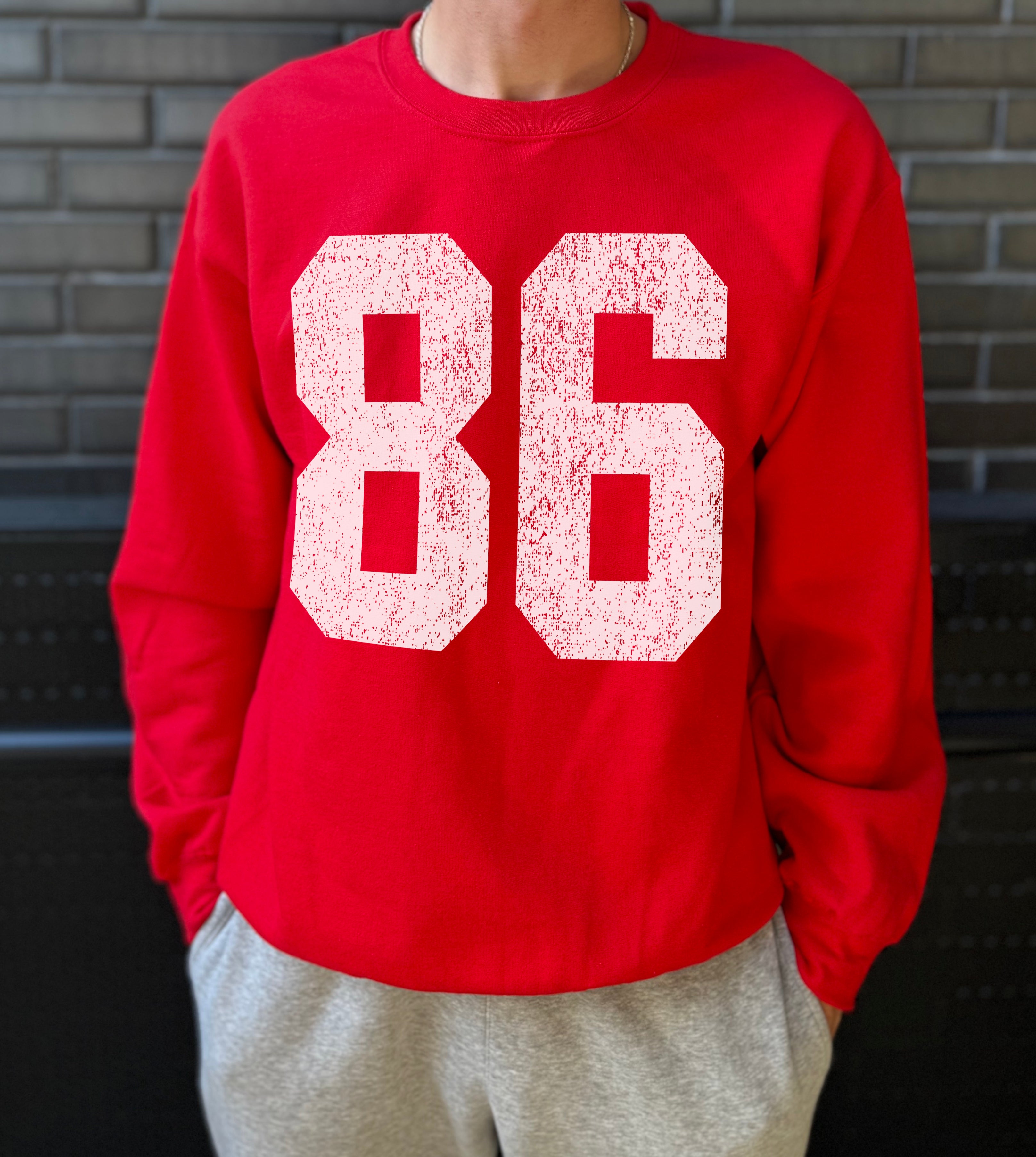Red colored pullover with white text that says "86"