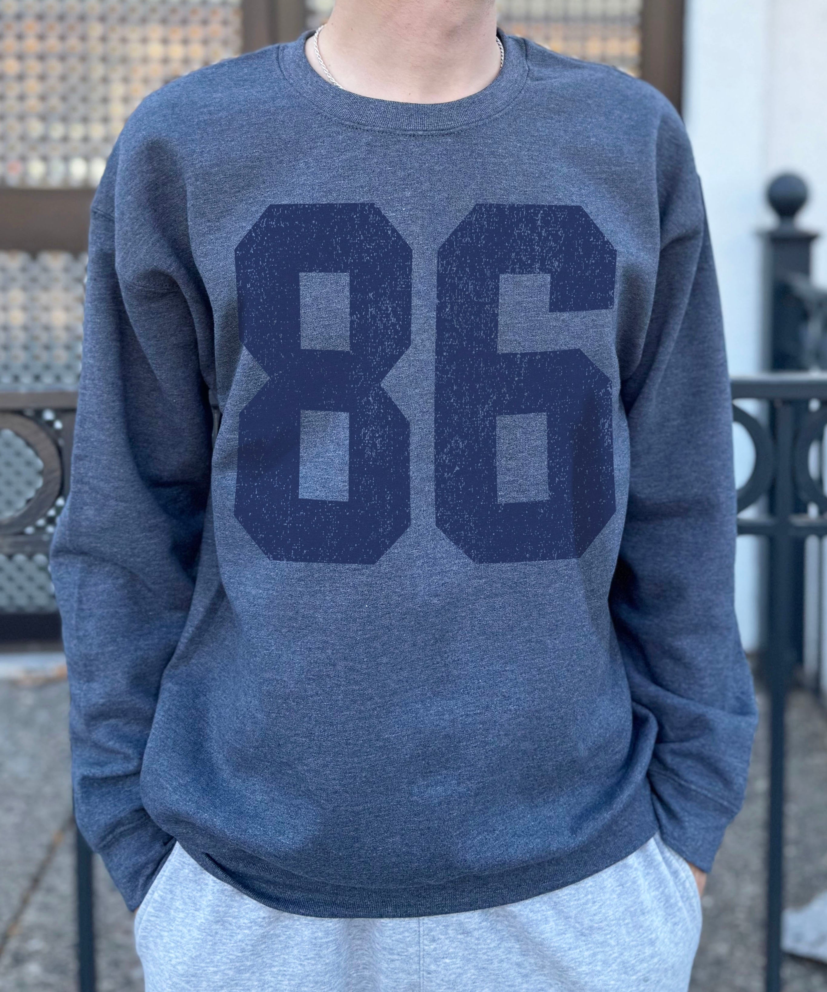 grey colored pullover with blue text that says "86"