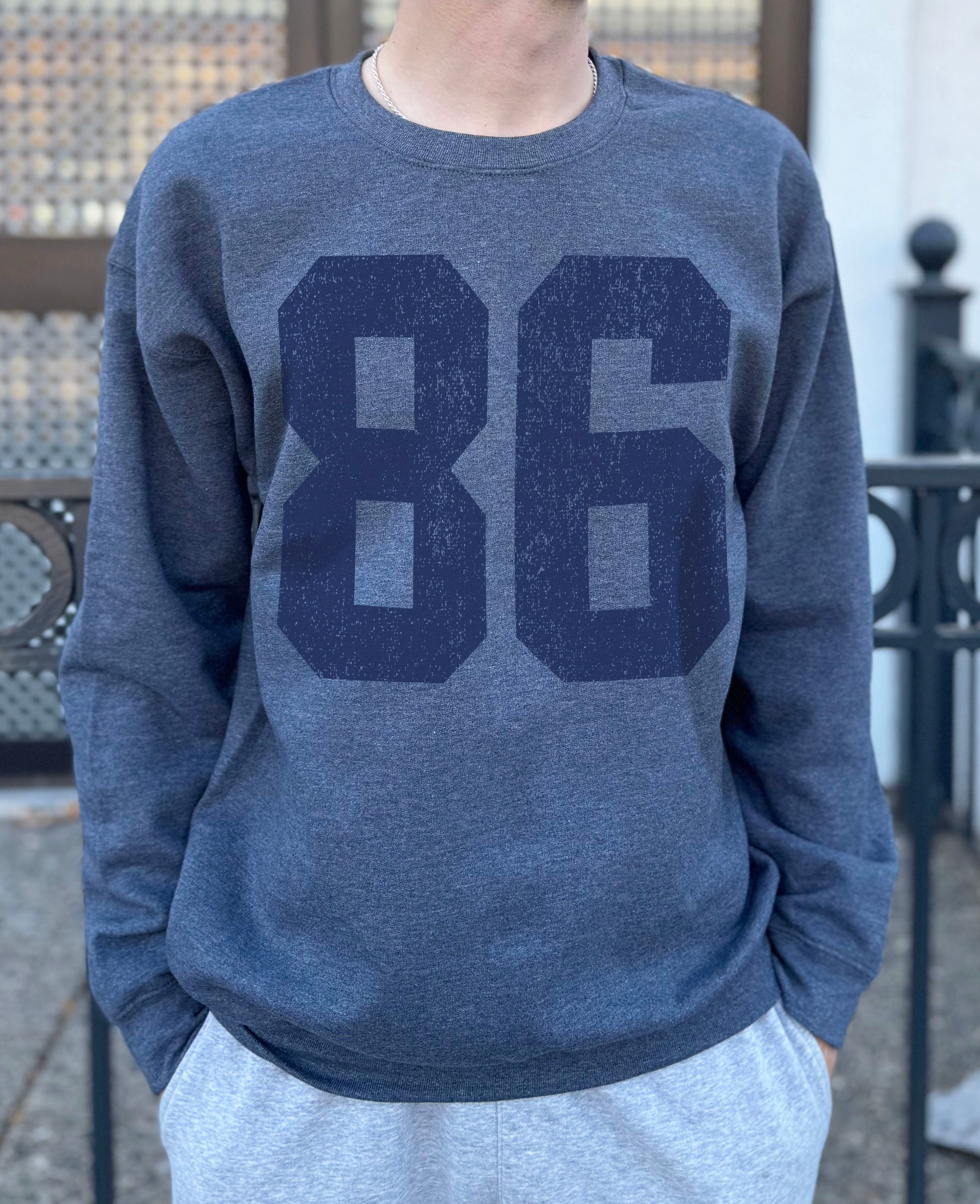 grey colored pullover with blue text that says "86"