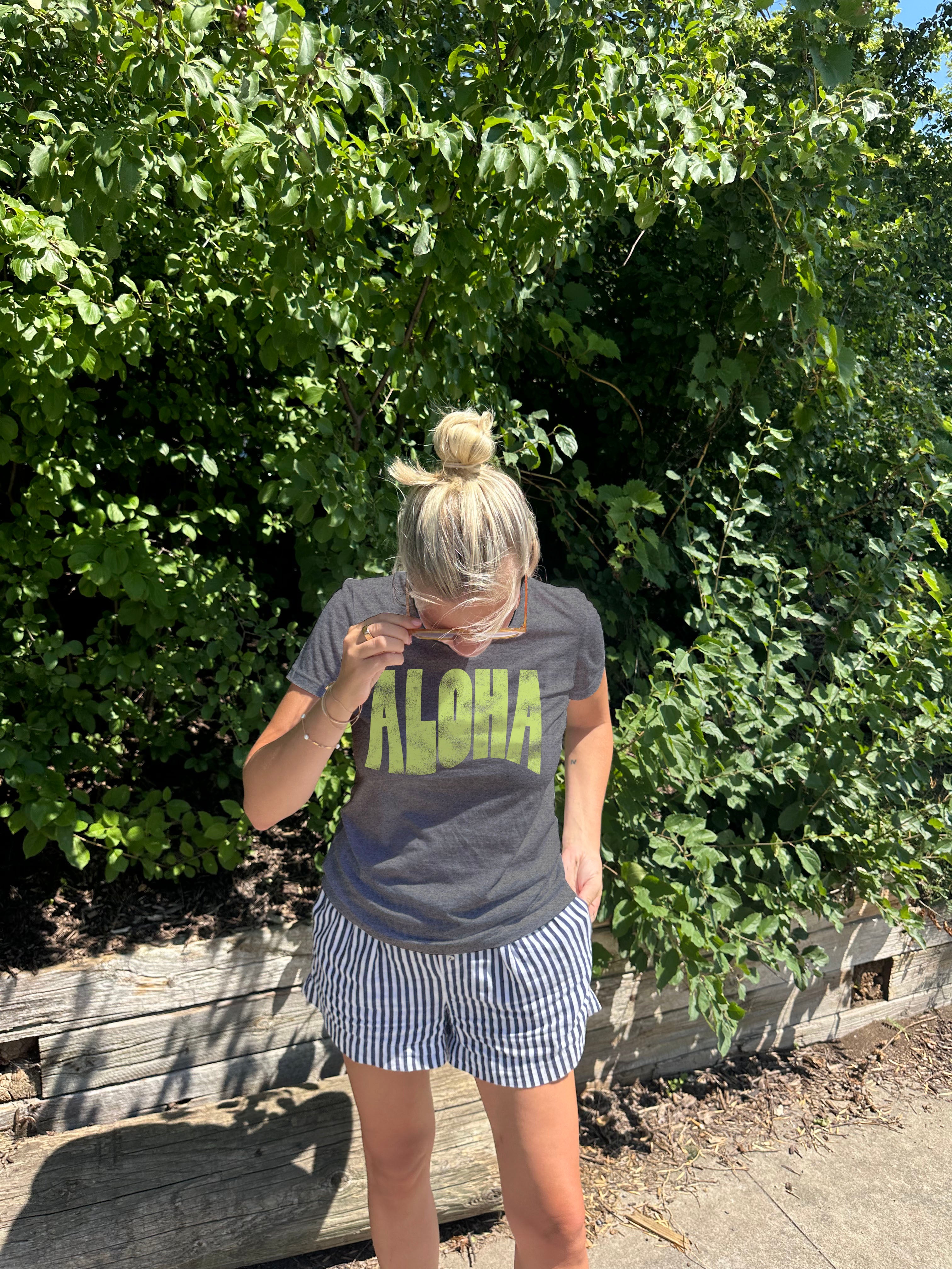 Grey Tee shirt that says Aloha in green letter from the front
