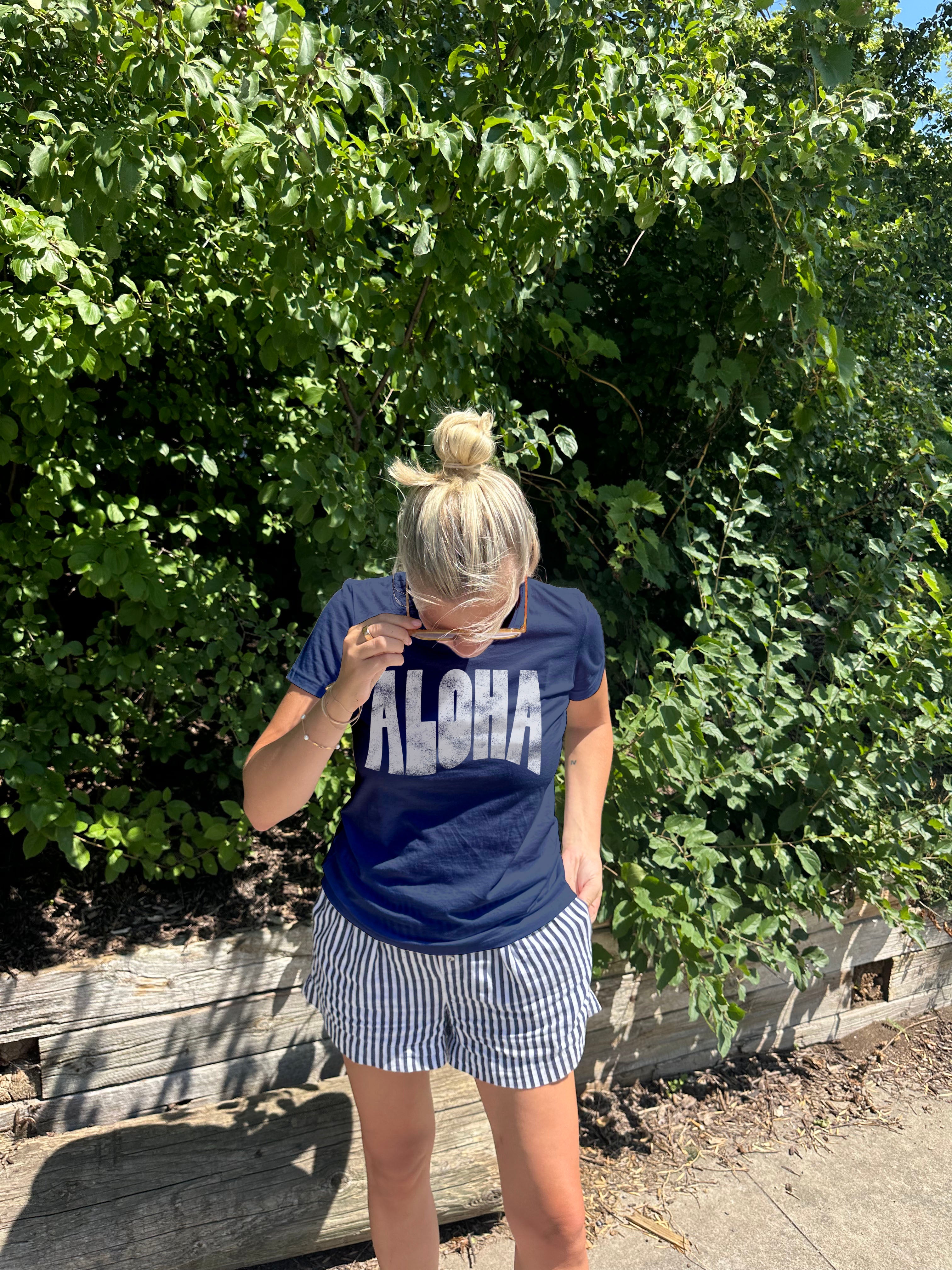 "Aloha" tee shirt in dark blue with white text on a  woman