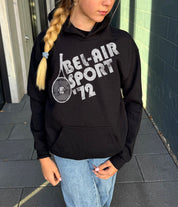 Girl in black hoodie that says "Bel-Air Sport 72" in white text