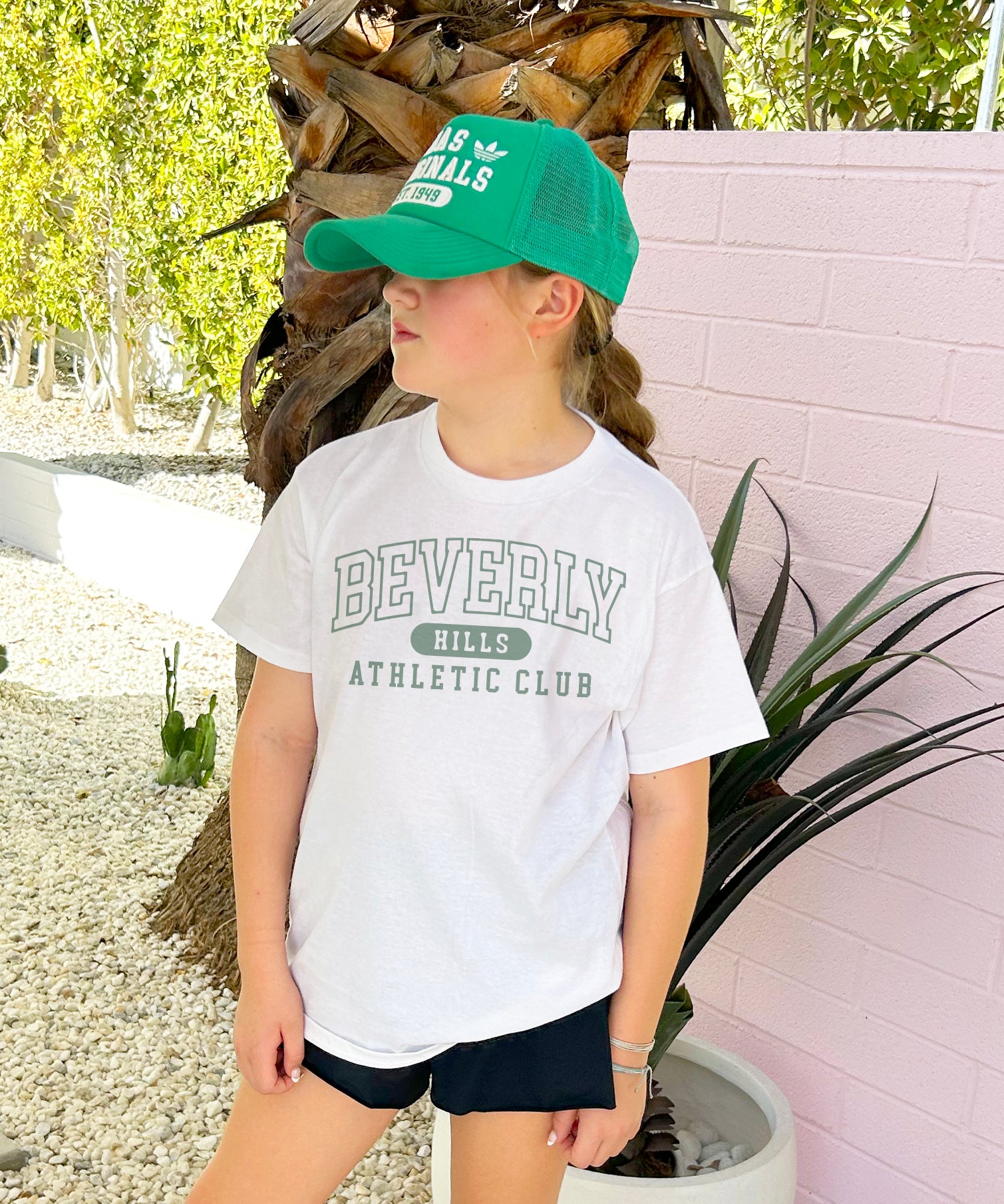 White tee shirt with green lettering that says "Beverly Hills Athletic Club"