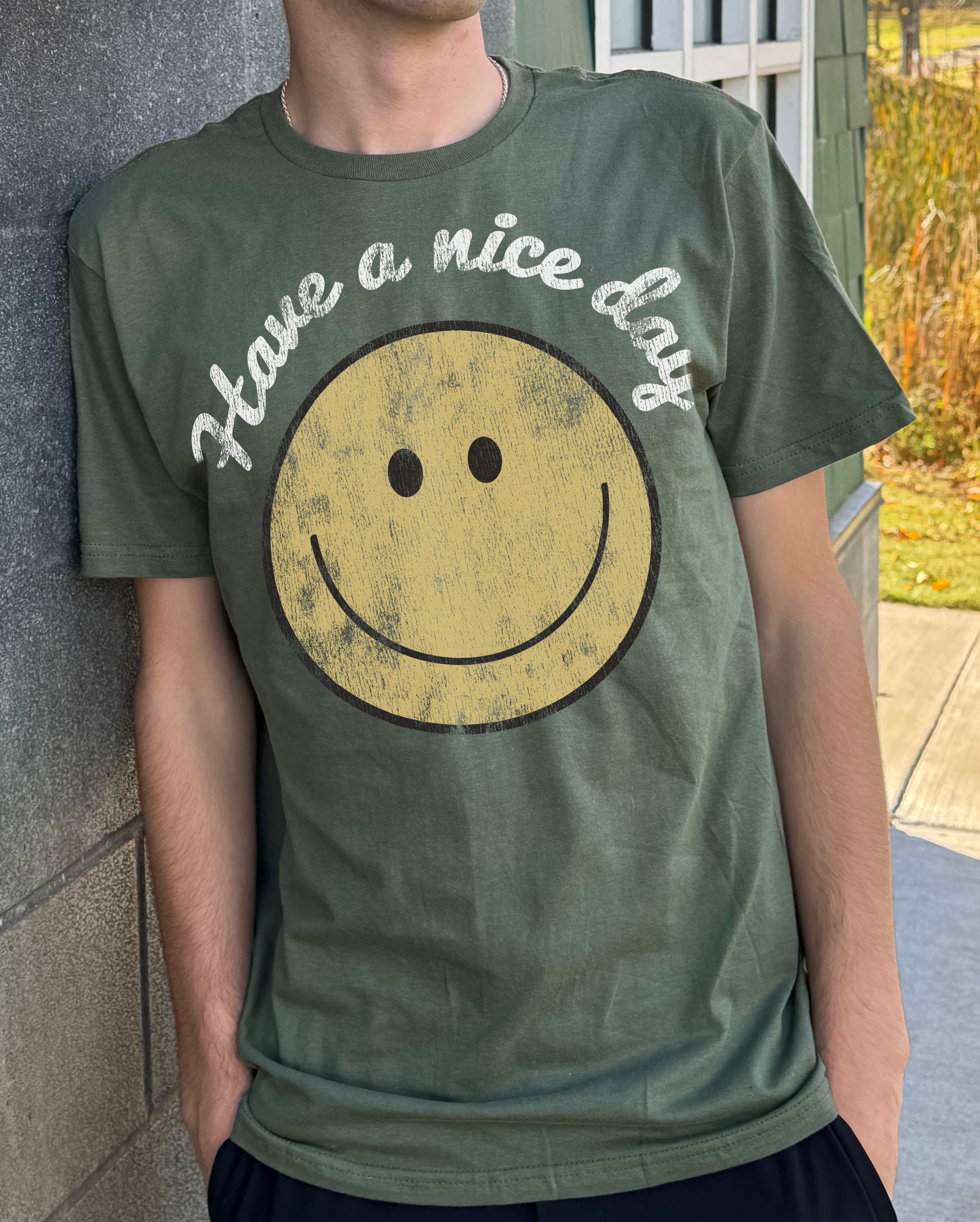 green mens tshirt that says "Have a nice day" with a smiling face