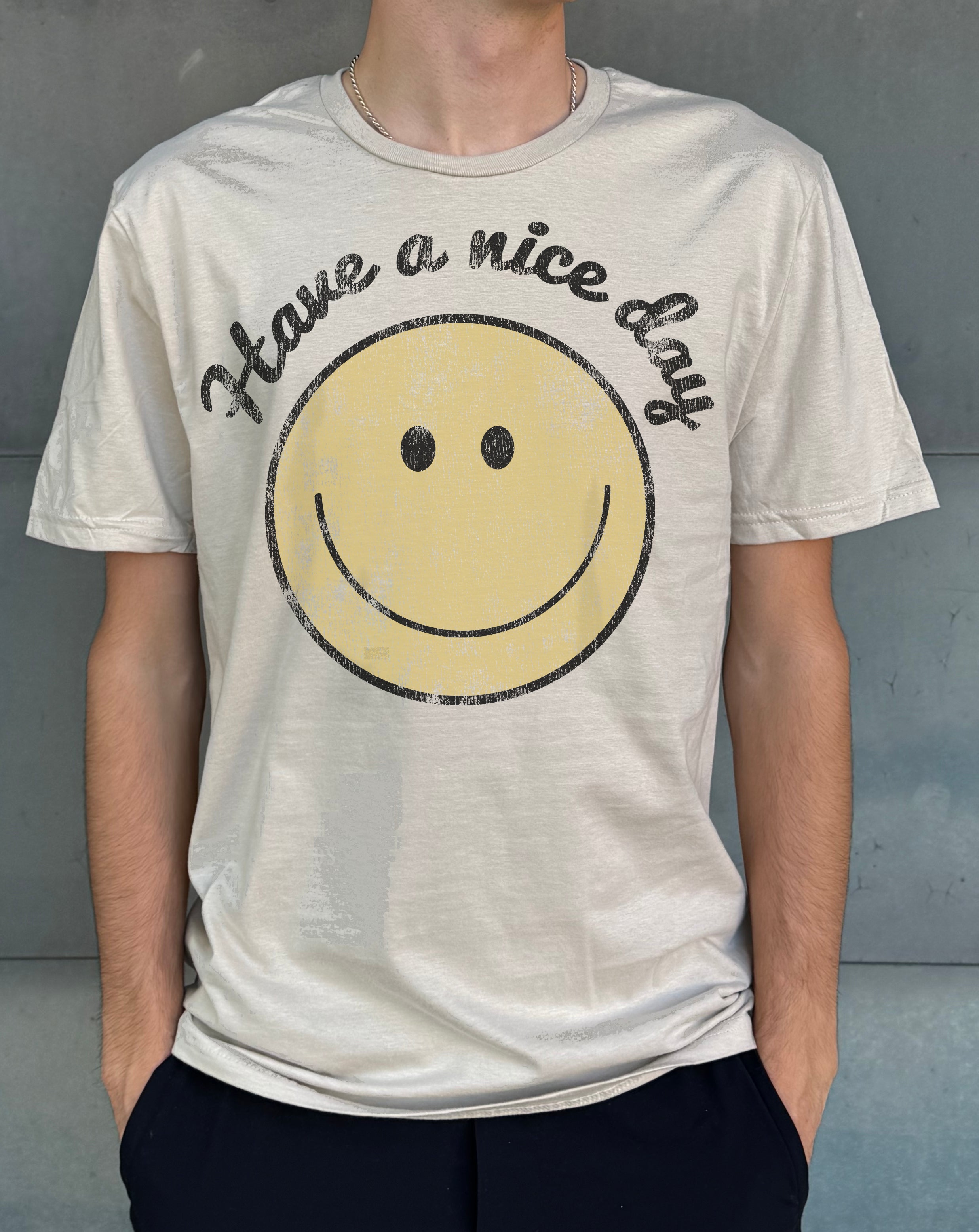 Sand colored mens tshirt that says "Have a nice day" with a smiling face