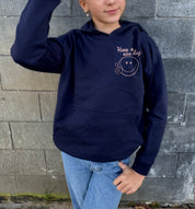 Girl in dark blue hoodie that says "Self Love Club" in rose text 