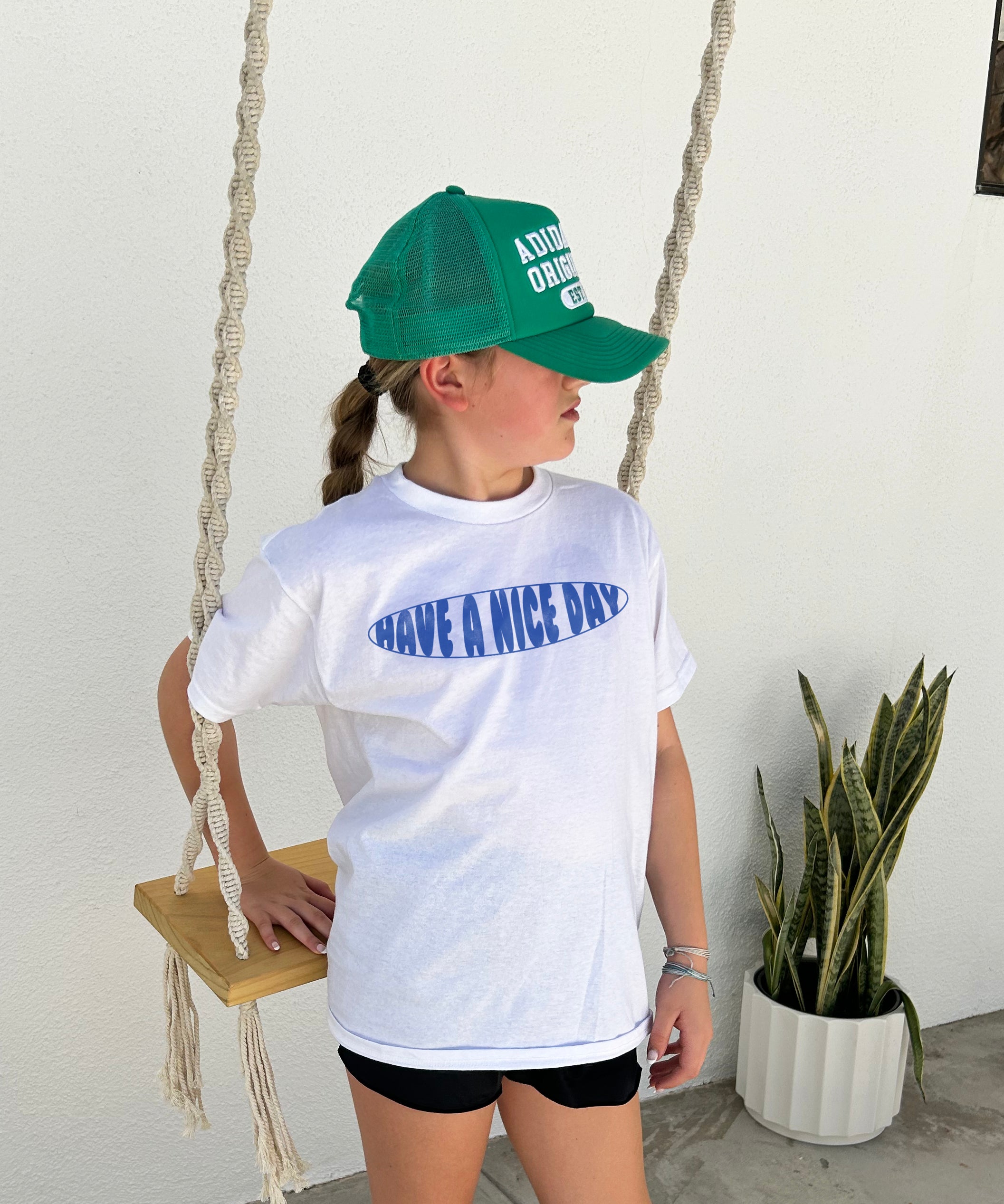 Girl in white shirt that says "Have a nie day" in blue text