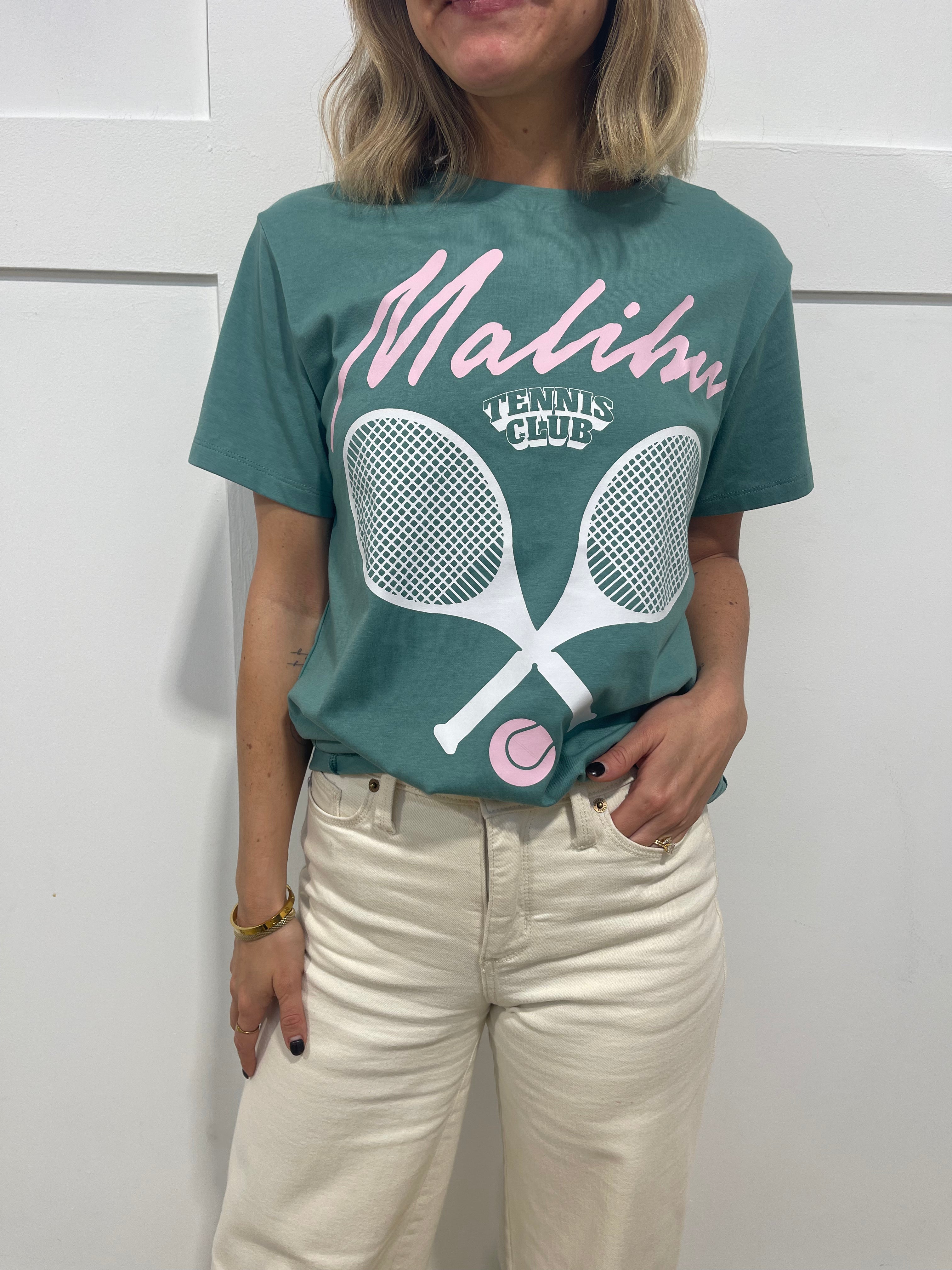 Woman in seafoam pullover that has pink text that says "Malibu"