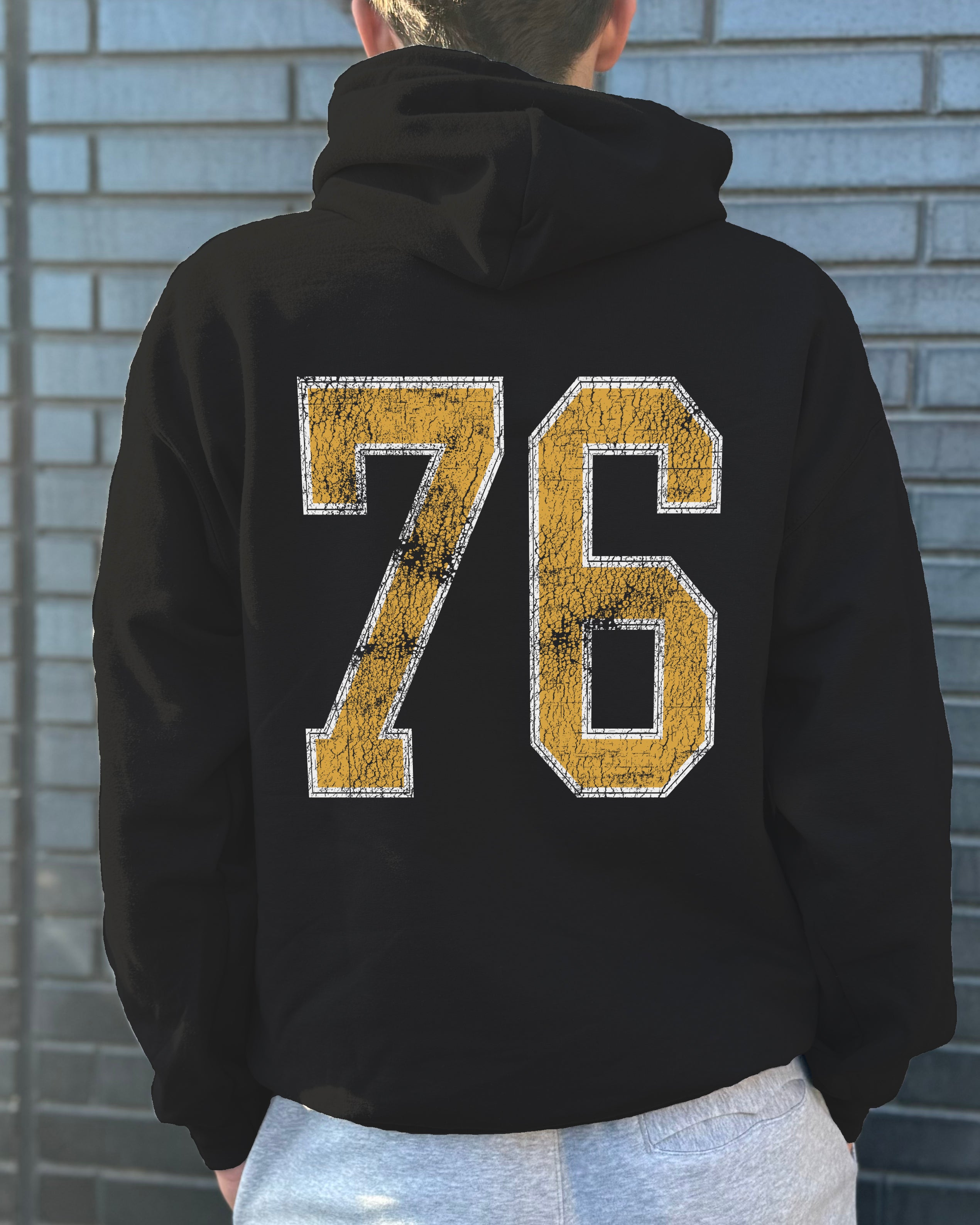 Black hoodie that says "76" in yellow text