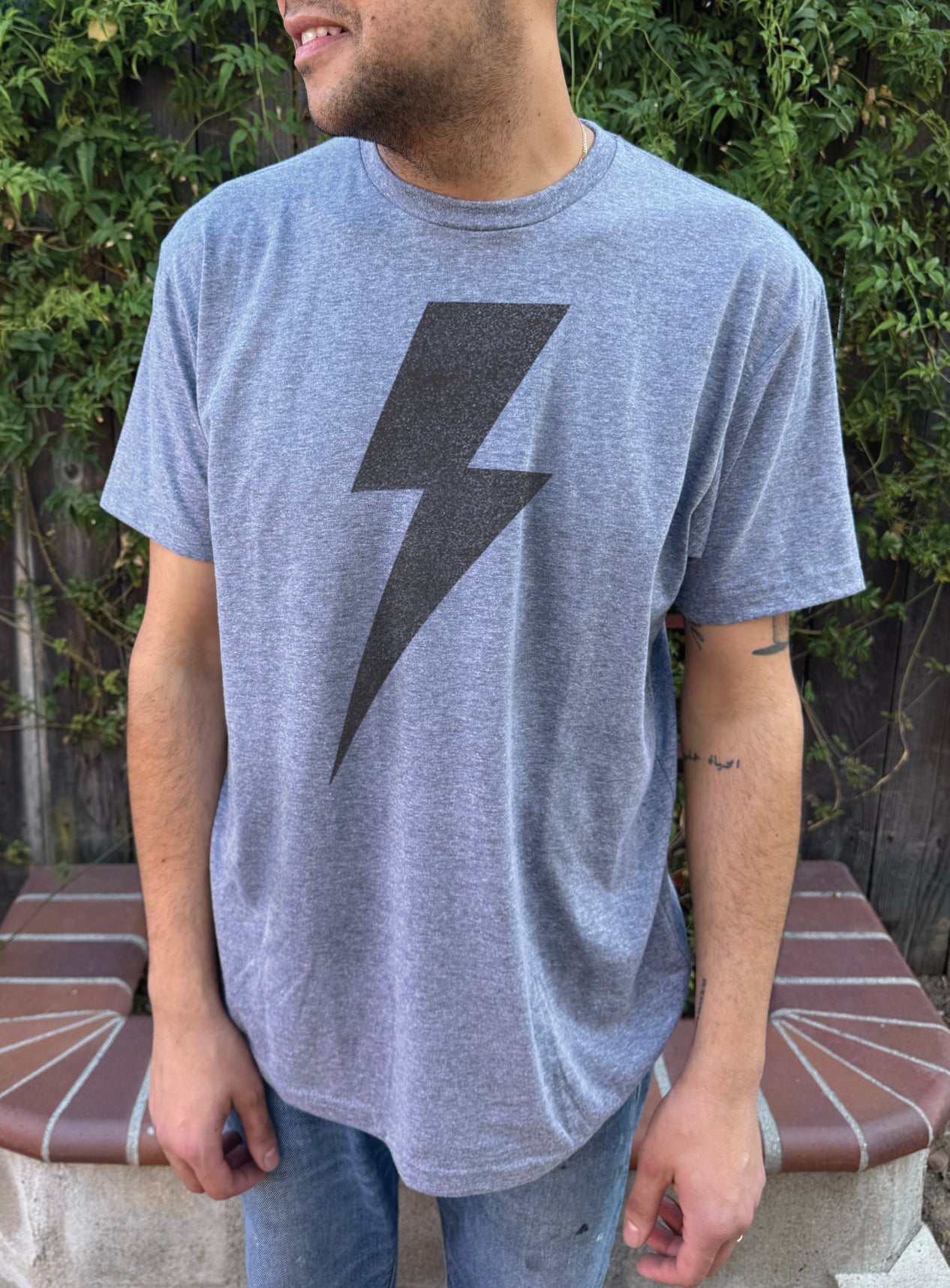 The boy's blue tee shirt with a grey lightning bolt symbol on the front