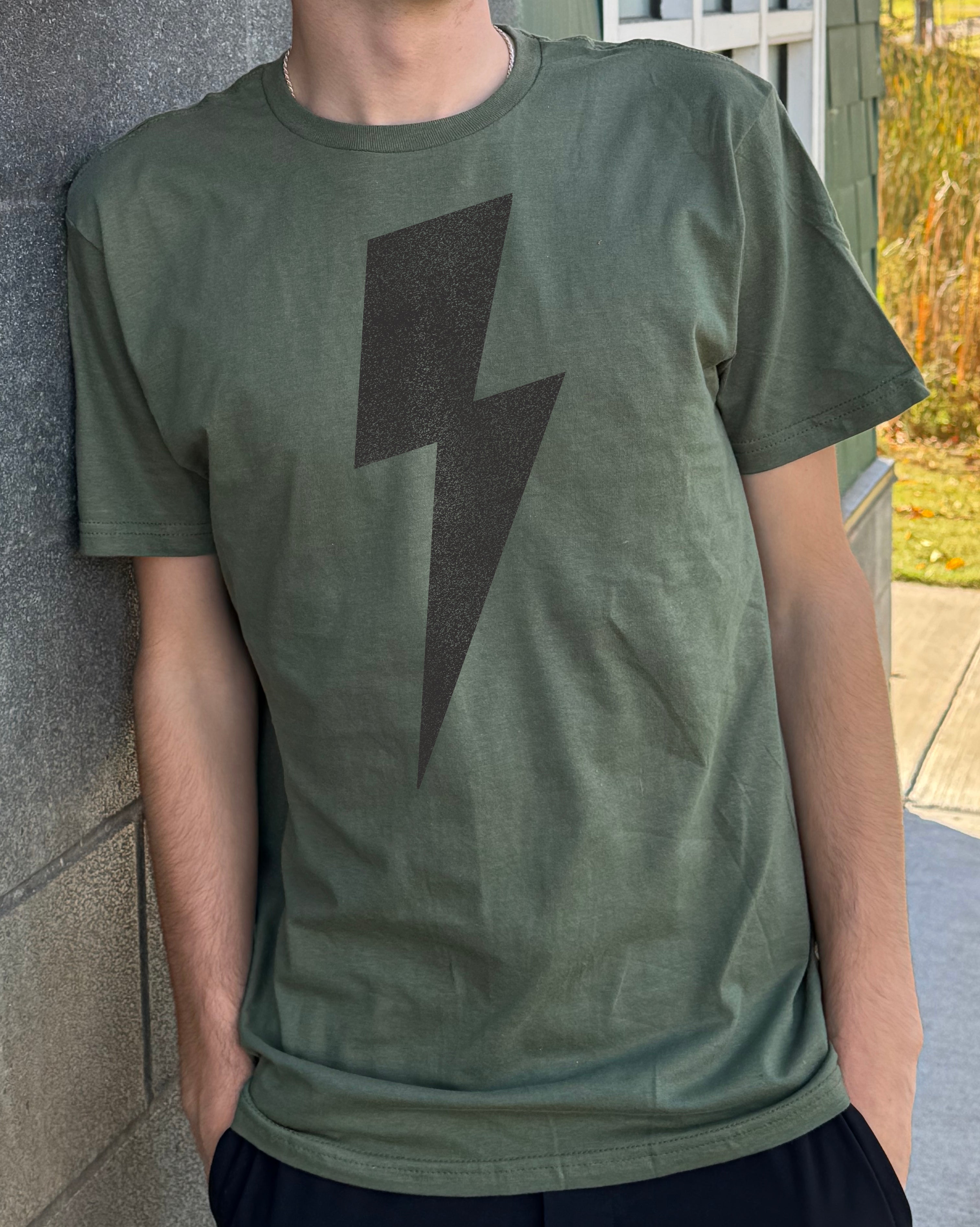 Boys green tee shirt with a gray lightning bolt symbol on front