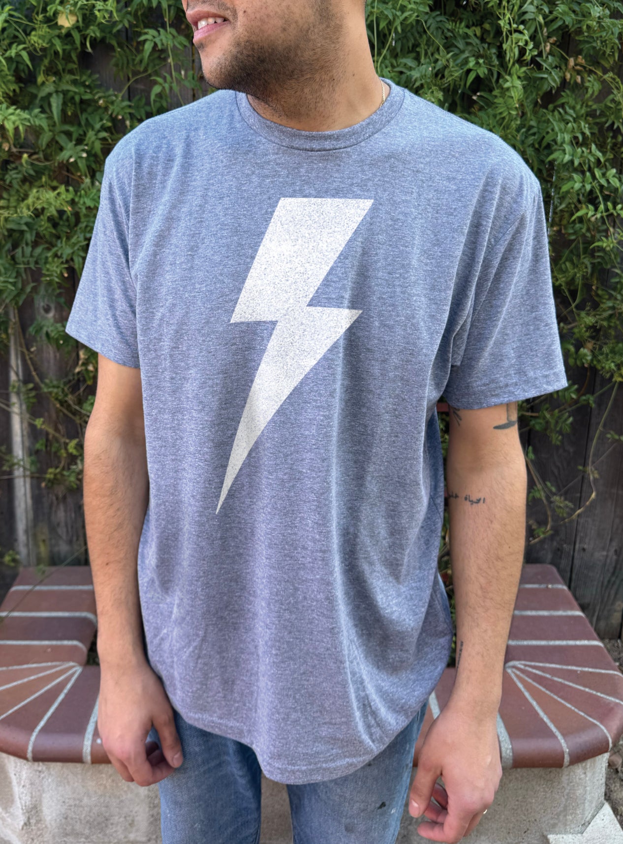 Boys blue tee shirt with a white lightning bolt symbol on the front