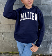 Girl in dark blue hoodie that says "Malibu" in white text
