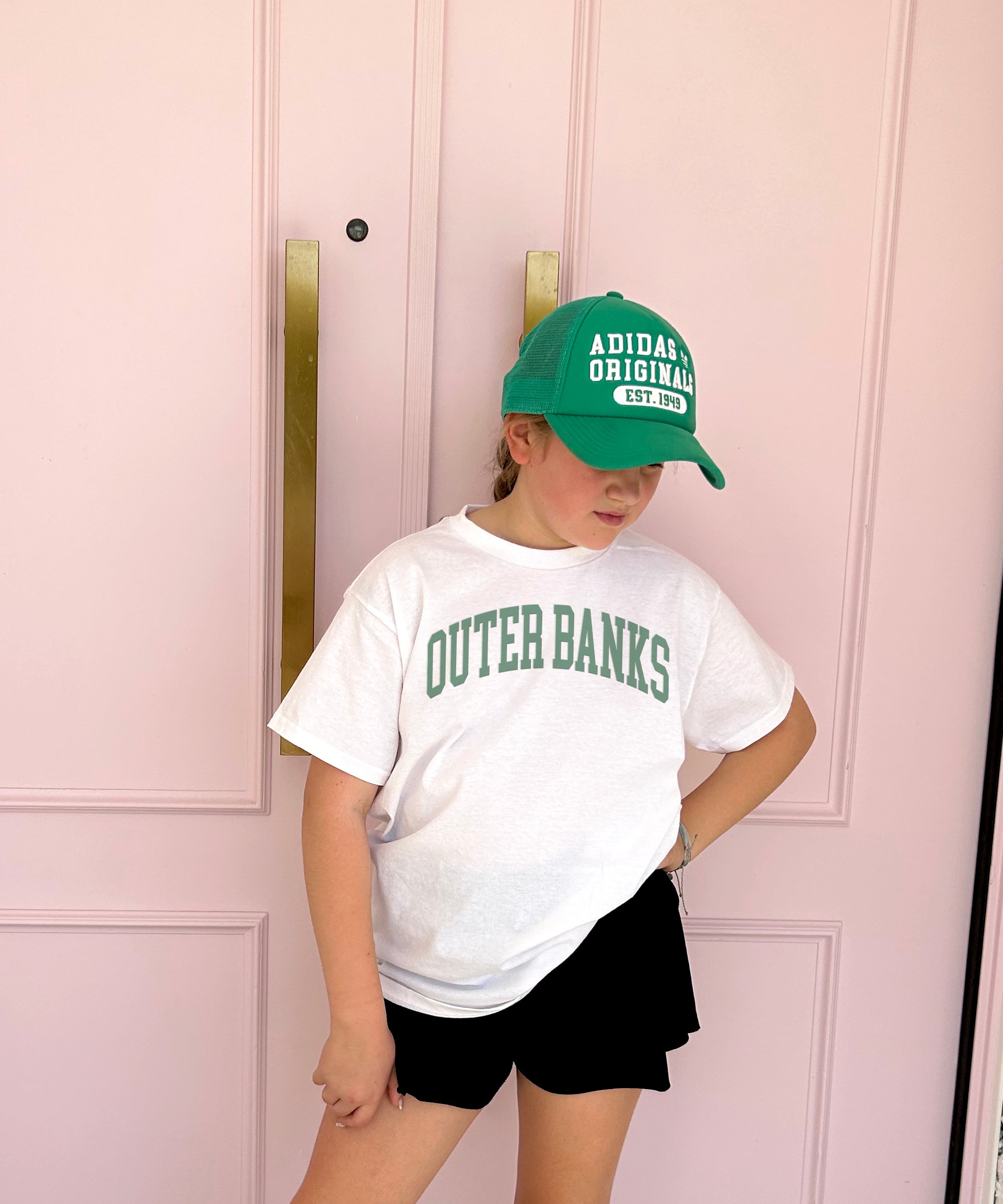 White tee shirt with green lettering that says "Outer Banks"