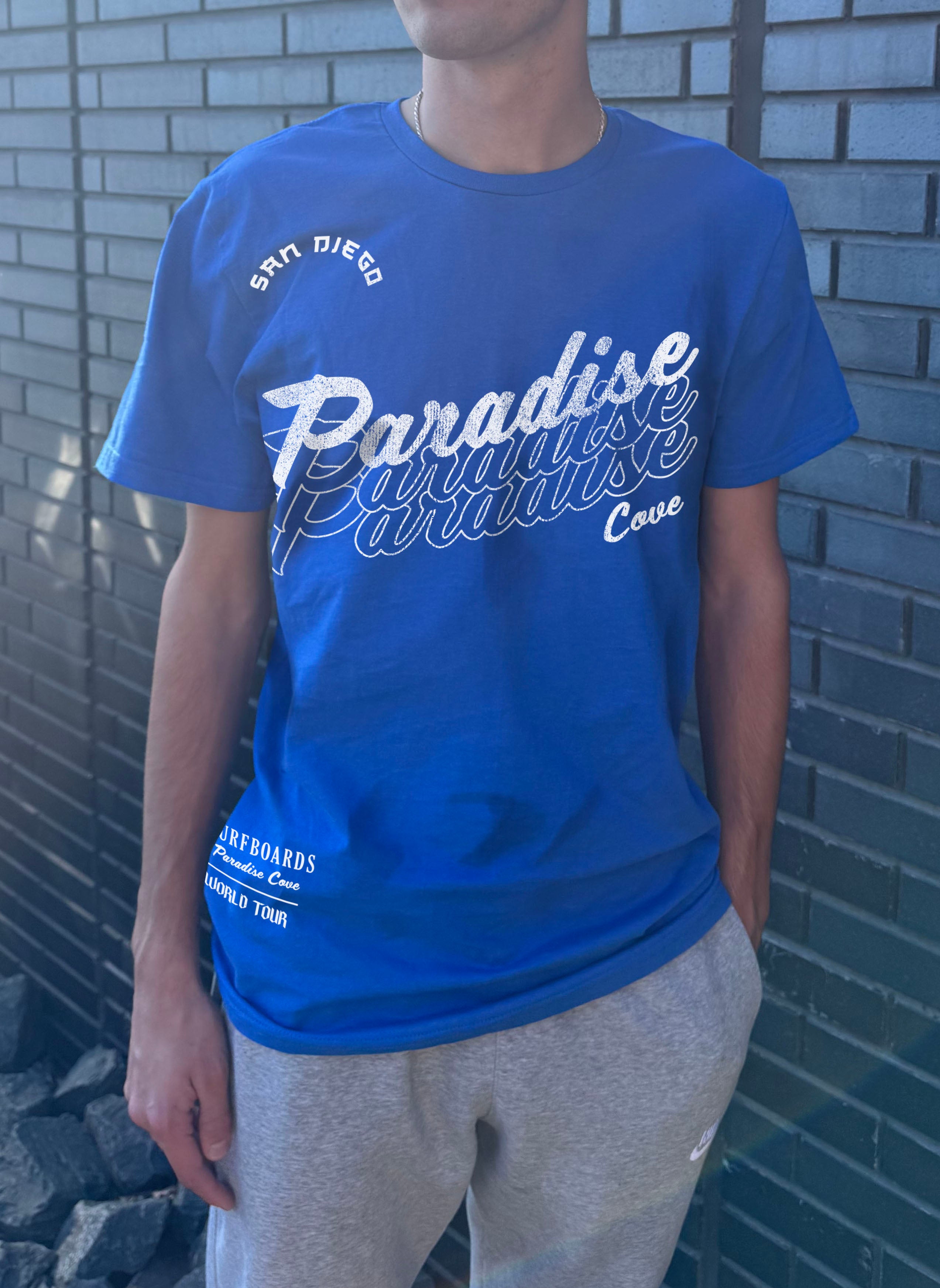 Boys shirt in blue that says "Paradise Cove" in white lettering