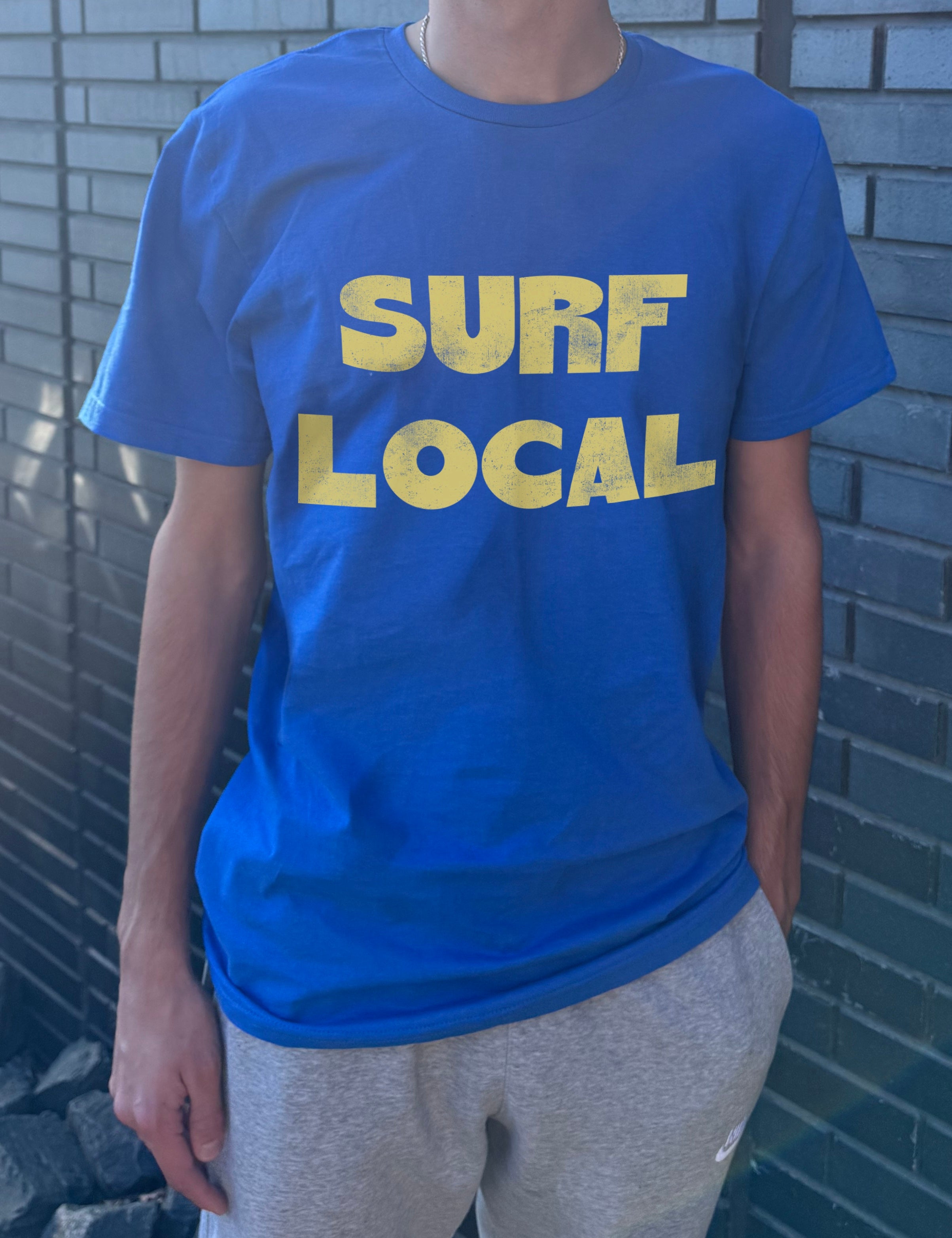 blue shirt with yellow text that says "Surf Local" for boys