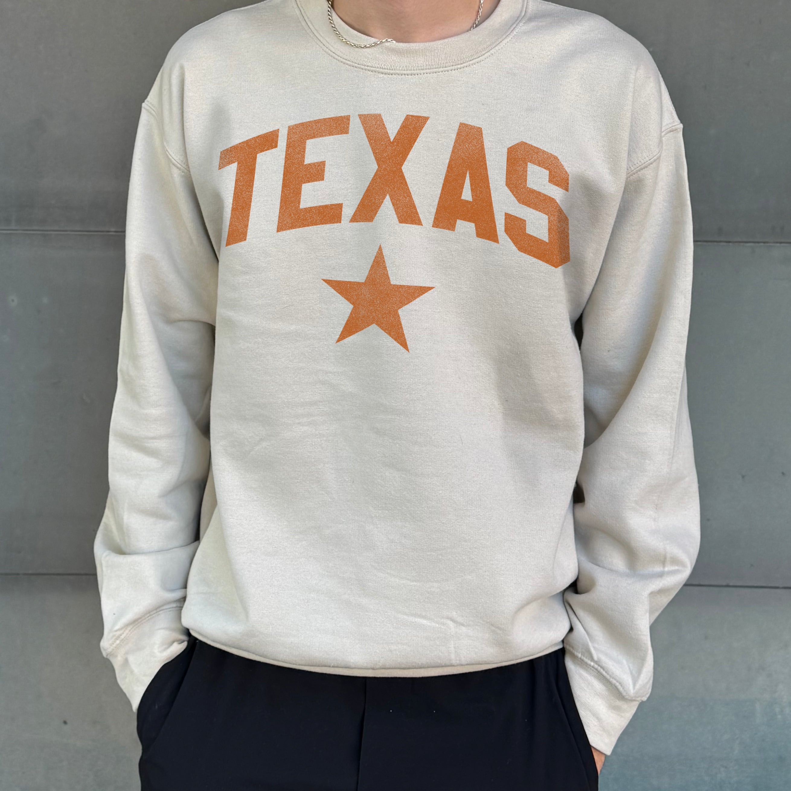 Sand colored pullover with orange text that says "Texas"