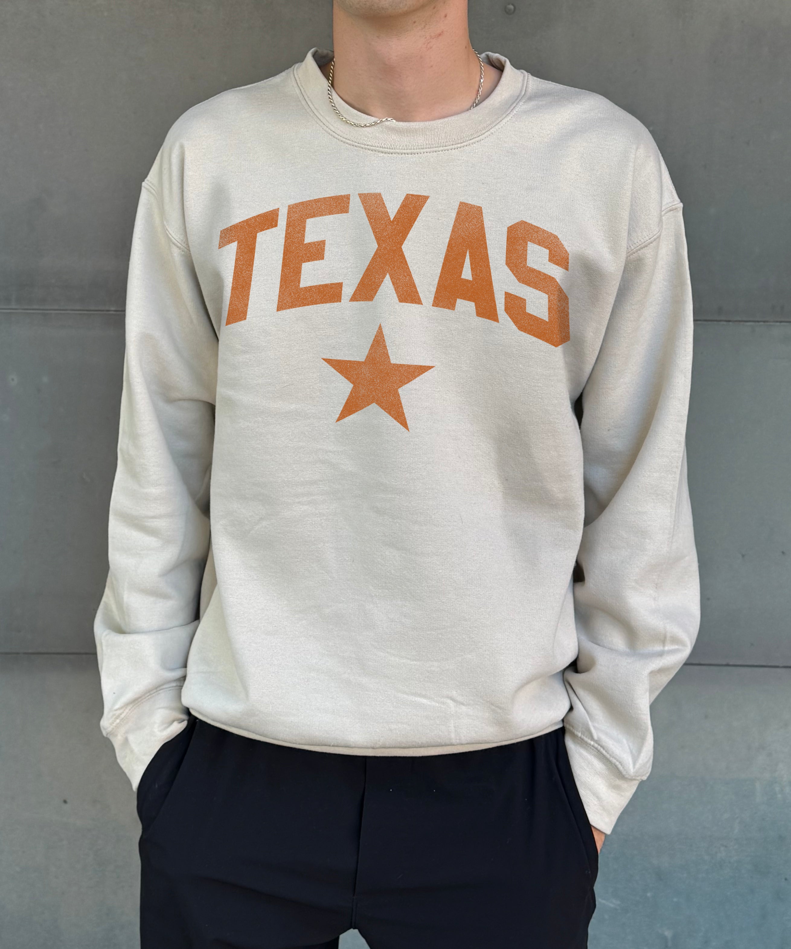 Sand colored pullover with orange text that says "Texas"