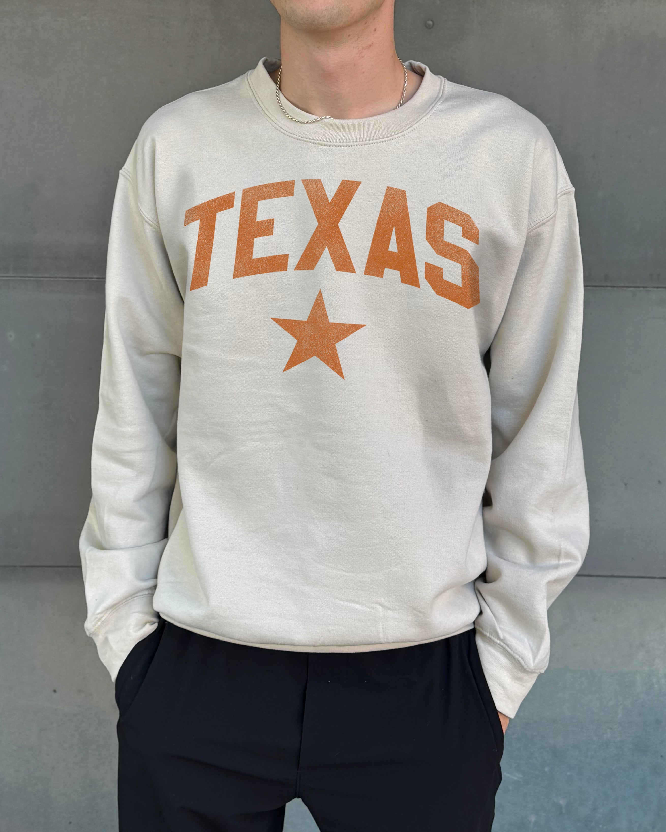 Sand colored pullover with orange text that says "Texas"