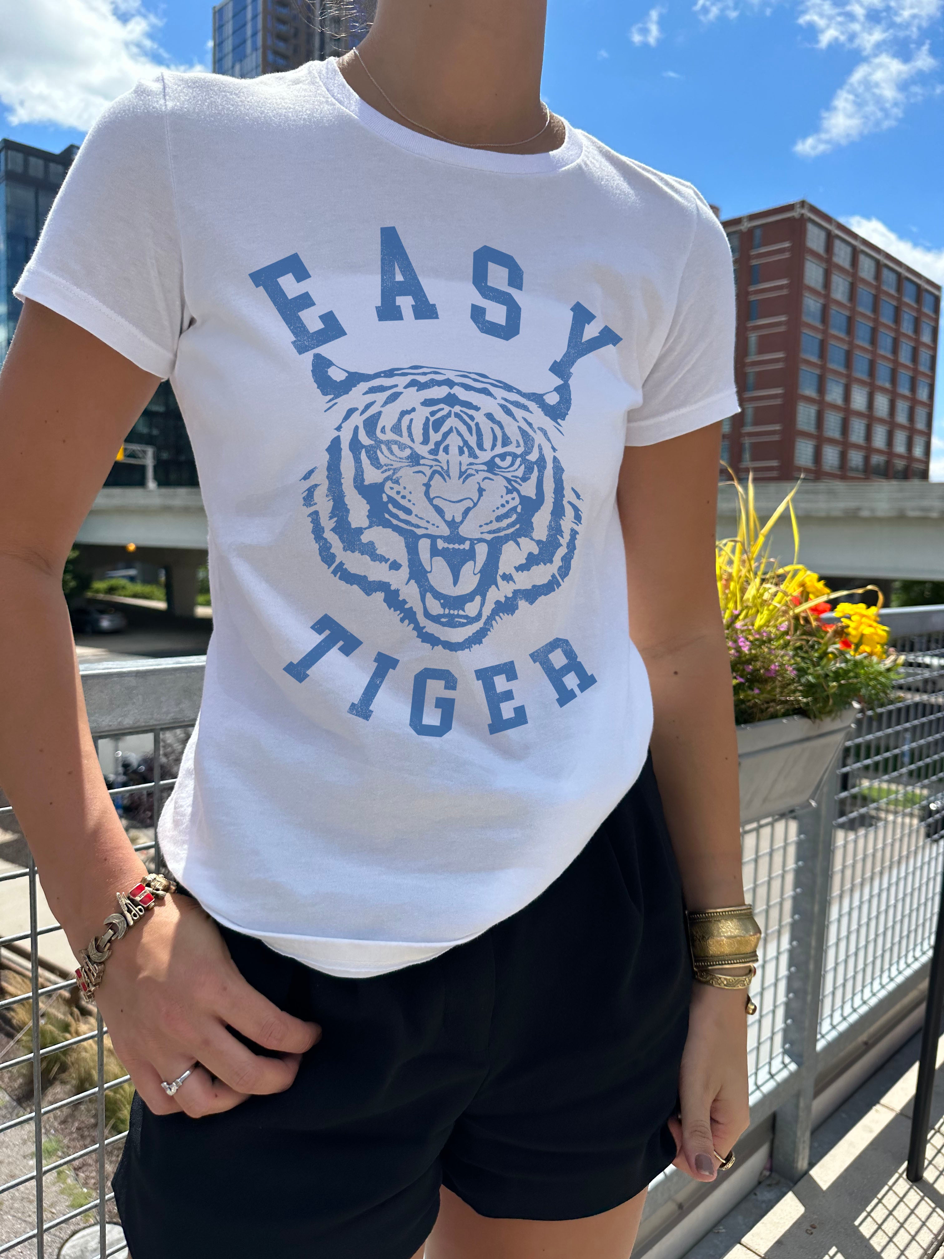 Easy Tiger in white with blue font and a tiger in the center on a women in Minneapolis